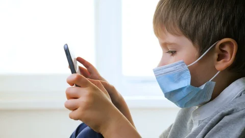 Boy on windowsill playing game. E-learning, home school background. Children and Stock Footage 129062947