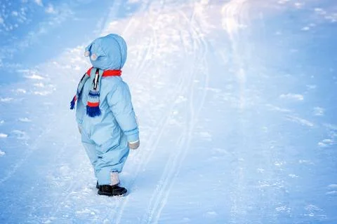 Boy in winter clothes at snowfall Stock Photos
