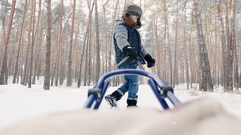 The boy in the winter hat carries sled Stock Footage 99638346
