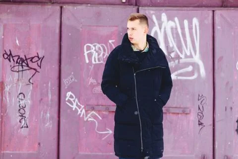 Boy in a winter jacket against the background of the wall Stock-Fotos