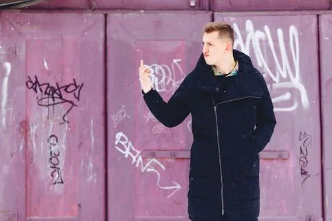 Boy in a winter jacket against the background of the wall Stock Photos
