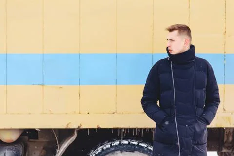 Boy in a winter jacket against the background of the wall Stock Photos