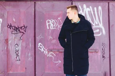 Boy in a winter jacket against the background of the wall Foto stock