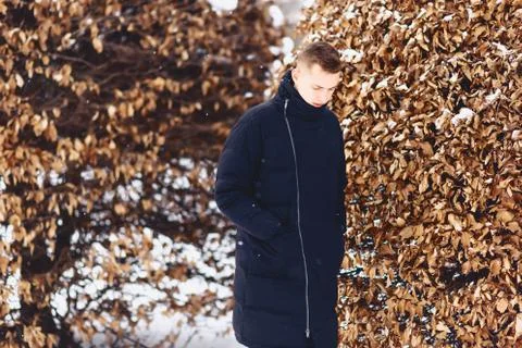 Boy in a winter jacket among the winter trees Foto stock