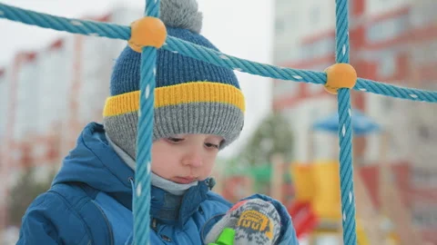 Boy in winter playing outside. Young child making bubbles at playground. Young Stock Footage 337726379