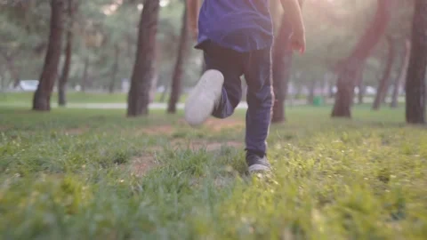 Boy without face running in the park with trees against of sunset. Happy child Stock Footage 201112879