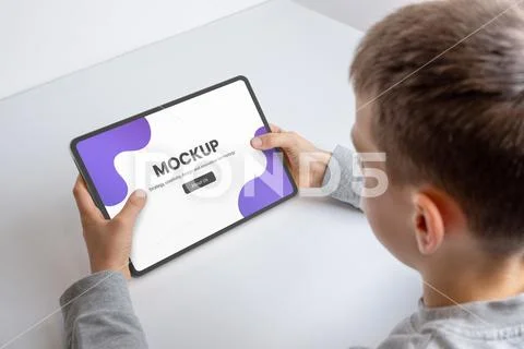Boy at work deskwith tablet mockup for game or app promotion PSD Template