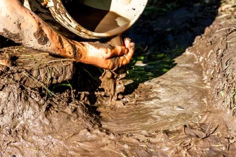 Boy working and playing in the mud Stock Photos