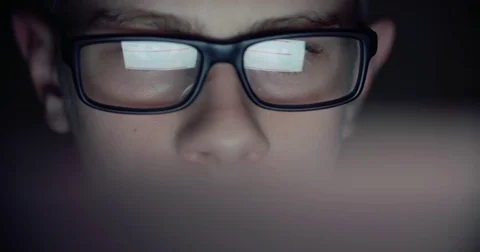 Boy working at a computer in a dark room, surfing the Internet, close-up Stock Footage 74227449