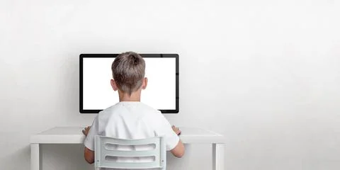Boy is working on the computer, his back is turned. Isolated computer display Stock Photos