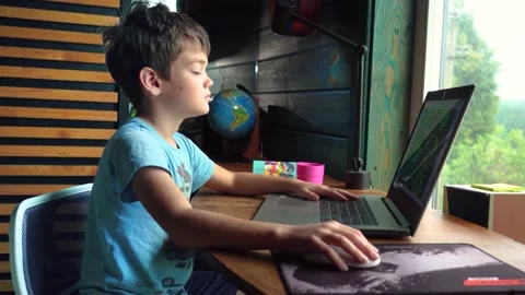 Boy working at the computer. stares at the laptop screen. doing homework Stock Footage 168235575
