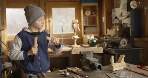 Boy working concentrated with hammer and carving Stock Footage 85778334