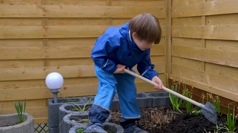 A boy working in the garden on a flower bed Stock Footage 152763848