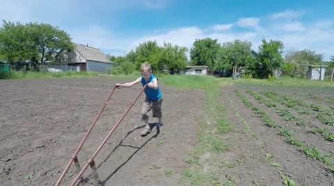 Boy working in the garden plow. Video stock 51401786