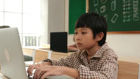 Boy working on his laptop while learning about coding prompt at class. Pedagogy. Foto stock