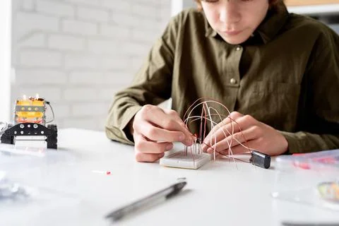 Boy working with LED lights on experimental board for science project Stock Photos