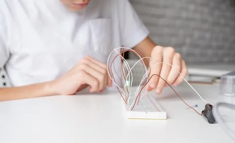 Boy working with LED lights on experimental board for science project Stock Photos