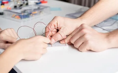 Boy working with LED lights on experimental board for science project Stock Photos