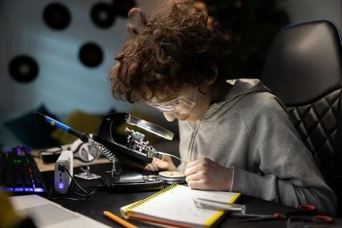 Boy works to create fully functional computer from scratch. A smart soldering Stock Photos