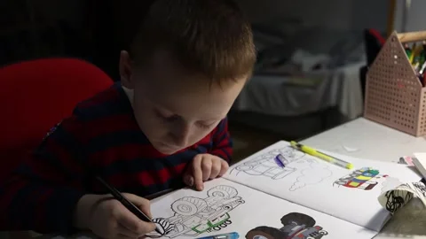 Boy works on his drawing in colouring book. Stock Footage 300501894