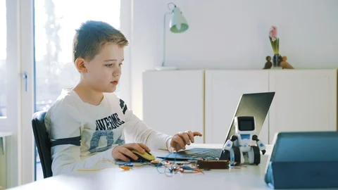 Boy works with science project in front of laptop and starts to type on keyboard Stock Footage 102175939