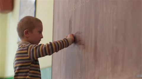 Boy writes on the blackboard at school Stock Footage 68594306