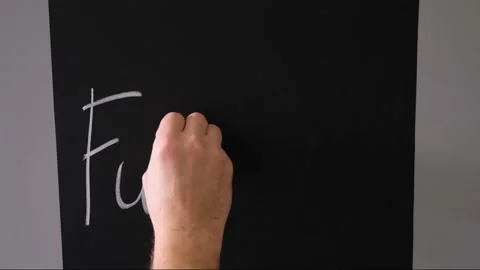 Boy writes on a chalk board with chalk the phrase fuck you Stock Footage 168816324