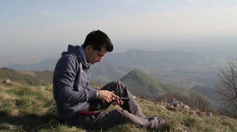 Boy writes in his diary, alone on the mountain Stock Footage 54283761