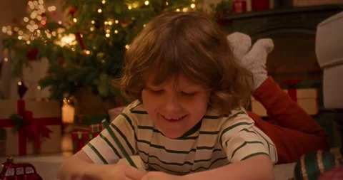 Boy writes a letter with wish list to Santa Claus Stock Footage 258250287