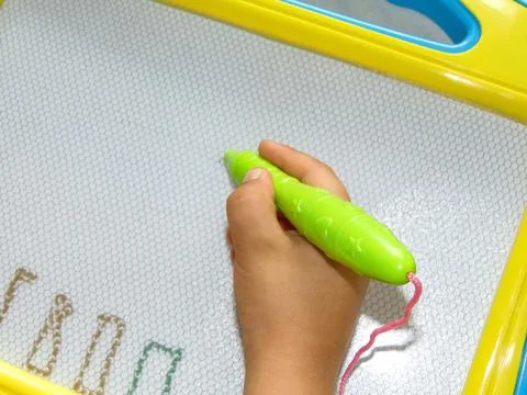 A boy writes on the magnetic board Stockfoto's