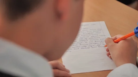 The boy writes with a pen text in a notebook in the classroom Stock Footage 108960501
