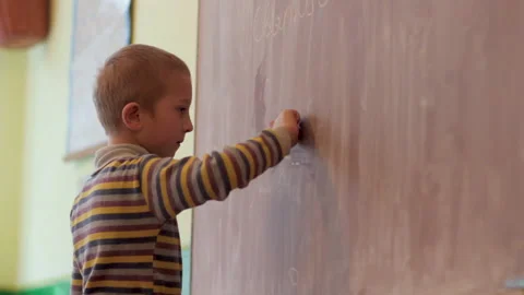 Boy writes on a school blackboard Stock Footage 150589496