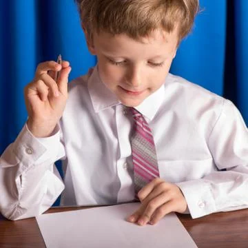 Boy writes on a sheet of paper Stock Photos