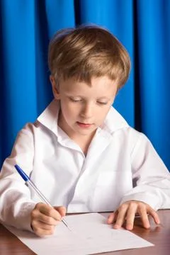 Boy writes on a sheet of paper Foto stock