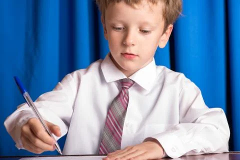 Boy writes on a sheet of paper Stock Photos
