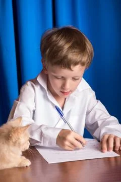 Boy writes on a sheet of paper Stock Photos