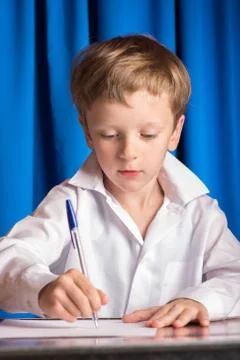 Boy writes on a sheet of paper Foto stock