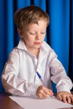 Boy writes on a sheet of paper Stock Photos