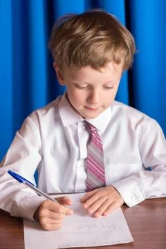 Boy writes on a sheet of paper Stock Photos