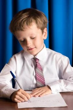 Boy writes on a sheet of paper Stock Photos