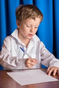 Boy writes on a sheet of paper Stock Photos
