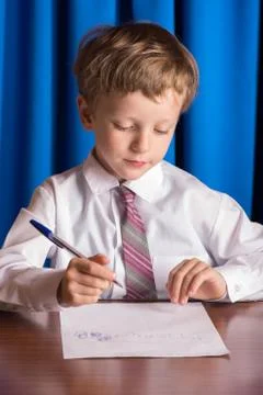 Boy writes on a sheet of paper Stock Photos