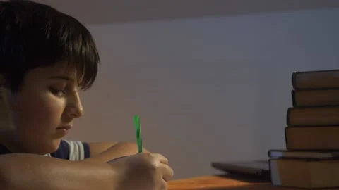 Boy writes at sitting table Stock Footage 146661678