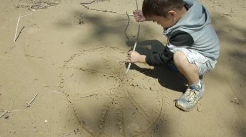Boy writes on wet sand Vidéo 54322559