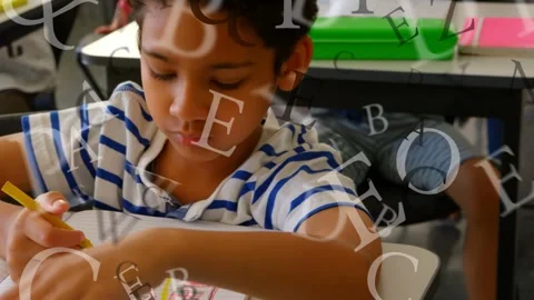 Boy writing for class after pencil touch in school, alphabet letters overlaying Stock Footage 335466061