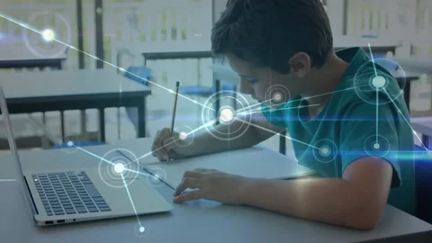 Boy writing at desk, node appearing and expanding network over him and laptop Stock Footage 331005311