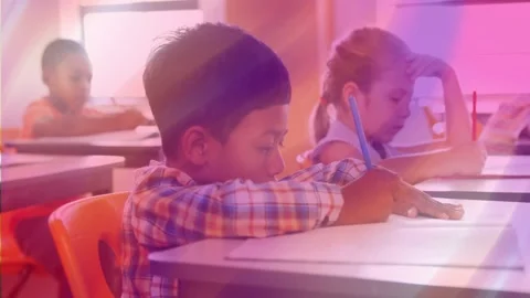 Boy writing at desk in school, pencil touching paper causing shifting purple Stock Footage 330652629
