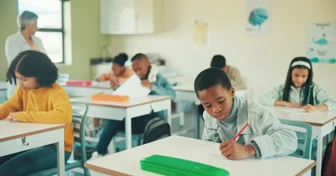 Boy, writing test and learning in classroom at school, assessment and devel.. Foto stock