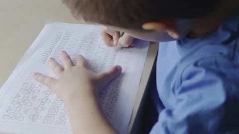 Boy writing on worksheet with pencil Stock Footage 159323861