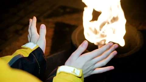 A boy in a yellow jacket crouched by the eternal flame of memory Stock Footage 187274615